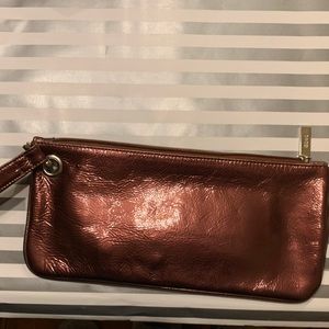 Shiny glossy Hobo International wristlet copper color silver hardware.